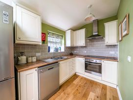 A kitchen with countertop, sink, and appliances at Bodior Garden Cottage Bach in Holyhead