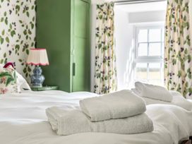 A bedroom with towels on the bed at Bodior Garden Cottage Bach Holyhead