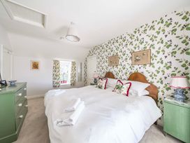 A bedroom with two beds and a green chest of drawers at Bodior Garden Cottage Bach Holyhead