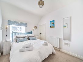 A bedroom with a bed and artwork on the wall at Bodior Garden Cottage Bach in Holyhead