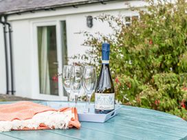 A tray with a bottle of prosecco and glasses on a table at Bodior Garden Cottage Bach Holyhead