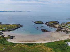 A beach with water and houses at Bodior Garden Cottage Bach Holyhead