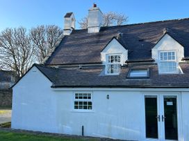 An exterior view of a house with windows and a door at Bodior Garden Cottage Bach in Rhoscolyn