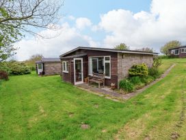A garden with a cabin and bench at Sea Breeze in Welcombe near Morwenstow