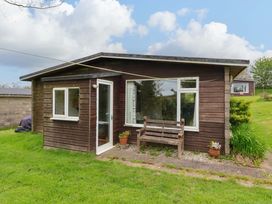 A wooden cabin with a bench and pot plant at Sea Breeze in Welcombe near Morwenstow