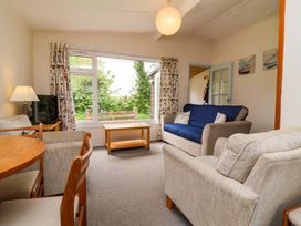 A living room with a sofa and table at Sea Breeze in Welcombe near Morwenstow