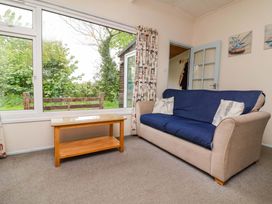 A living room with a sofa and table at Sea Breeze in Welcombe near Morwenstow