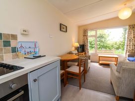 A living room with a table and chairs at Sea Breeze in Welcombe near Morwenstow