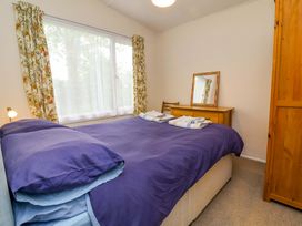 A bedroom with a bed and mirror at Sea Breeze in Welcombe near Morwenstow
