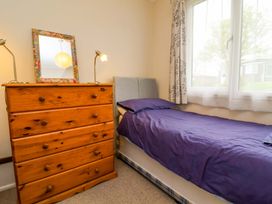 A bedroom with a single bed and a wooden chest of drawers at Sea Breeze near Morwenstow
