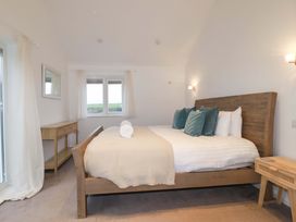 A bedroom with a bed and mirror at Poldreth in Truro