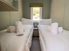 A bedroom with two single beds and a window at No.6 - The Pines in Delamere