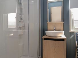 A bathroom with a shower, sink, and mirror at No.6 - The Pines, Delamere