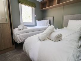 A bedroom with two beds and towels at No.6 - The Pines, Delamere