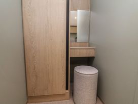 A dressing room with a mirror and stool at No.6 - The Pines in Delamere