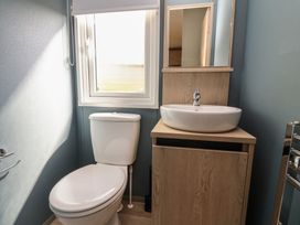 A bathroom with a sink, toilet, and window at No.6 - The Pines in Delamere