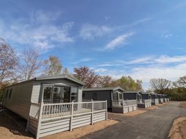 A row of mobile homes with decks in an outdoor area at No.6 - The Pines Delamere