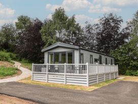 A mobile home with a deck and pathway at The Pines 3 Bedrooms in Delamere