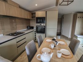 A kitchen with a dining table set for a meal at The Pines 3 Bedrooms in Delamere