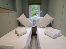 A bedroom with two single beds and towels on them at The Pines 3 Bedrooms in Delamere