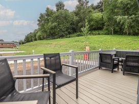 An outdoor area with chairs on a decking at The Pines 3 Bedrooms Delamere