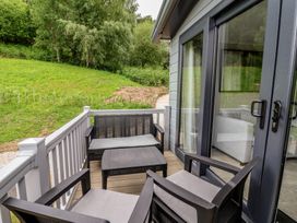 A terrace with chairs and a table at The Pines 3 Bedrooms Delamere