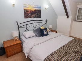 A bedroom with a bed and nightstand at Rhosgranog Cottage, Llandeloy near Solva