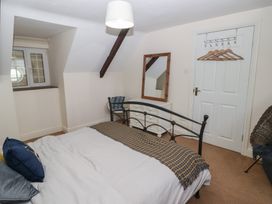 A bedroom with a bed, window, and mirror at Rhosgranog Cottage in Llandeloy near Solva