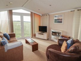 A living room with a TV and sofa at Rhosgranog Caravan in Llandeloy near Solva