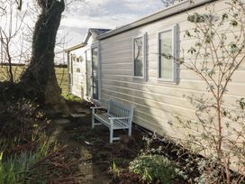 An outdoor area with a caravan and a bench at Rhosgranog Caravan Llandeloy near Solva