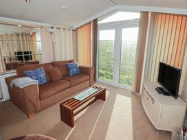 A living room with a sofa and coffee table at Rhosgranog Caravan Llandeloy near Solva