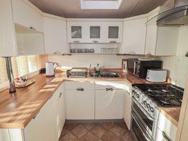 A kitchen with various appliances and cabinets at Rhosgranog Caravan in Llandeloy near Solva