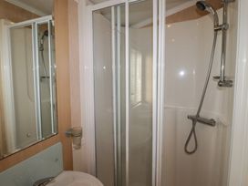 A shower and sink in a bathroom at Rhosgranog Caravan in Llandeloy near Solva
