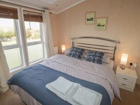 A bedroom with a bed and bedside table at Rhosgranog Caravan in Llandeloy near Solva