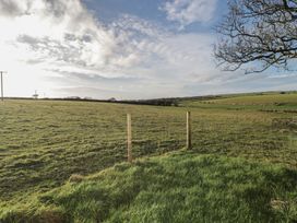 A grassy field with a fence and power lines at Rhosgranog Caravan Llandeloy near Solva