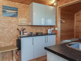 A kitchen area with cupboards and sink at Rhosgranog Shepherds Hut Llandeloy near Solva