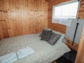 A bedroom with a bed and towels at Rhosgranog Shepherds Hut Llandeloy near Solva