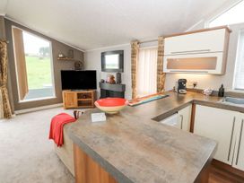 A living room with a sofa and television at No 8 Hillcote Lodge Cockermouth