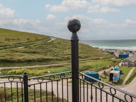 A view from a balcony overlooking a hill and the sea at Beachcombers Apt 11