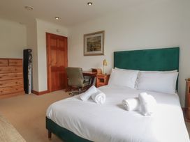 A bedroom with a green headboard and a wooden desk at Beachcombers Apt 11 