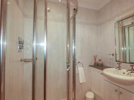 A bathroom with a shower and sink at Beachcombers Apt 11