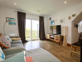 A living room with a television on a TV stand at Lowenna Watergate Bay near Newquay
