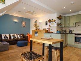 A living room with a sofa and kitchen unit at Lowenna Watergate Bay near Newquay