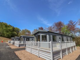 Three cabins with decks and railings in a natural setting at No.20 - The Oaks in Delamere
