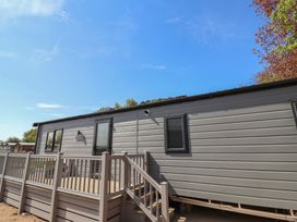 A mobile home with a deck and steps at No.20 - The Oaks Delamere