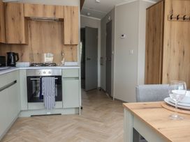 A kitchen with appliances and dining area at No.20 - The Oaks Delamere