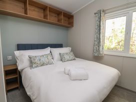 A bedroom with a double bed and bedside table at No.20 - The Oaks in Delamere