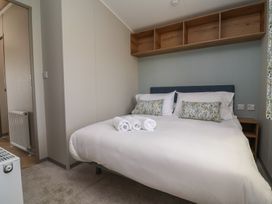A bedroom with a bed and bedside table at No.20 - The Oaks Delamere