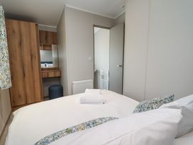 A bedroom with a bed and wardrobe at No.20 - The Oaks, Delamere