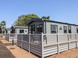 A row of cabins with a wooden fence at The Oaks 2 Bedrooms in Delamere